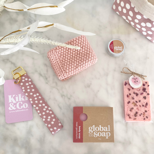 Gift Box NZ | New Zealand made products | Small gift boxes NZ | Gift in New Zealand Gift box with rose pink inspired products. Rose geranium soap & berry lip balm. White Chocolate & Raspberry Chocolate. Pink linen key chain. Pale pink knitted wash cloth. Sustainable reusable cotton fabric gift box . NZ handcrafted.