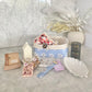 Gift Box NZ | New Zealand made products | Small gift boxes NZ | Gift in New Zealand |  A large size gift box jam packed with handmade products, all packaged in a pretty blue daisy fabric box. Leaf shaped trinket tray in white. Large white soy wax blend Home candle. Set of two produce bags.
