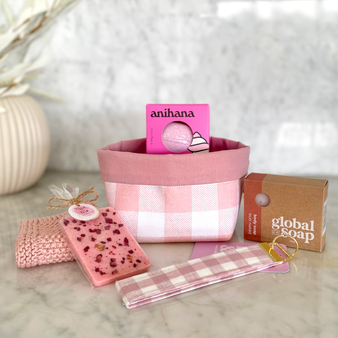 Gift Box NZ | New Zealand made products | Small gift boxes NZ | Gift in New Zealand | A gift box filled with raspberry pink inspired products in a cute dotty fabric box with blue floral rose. Butt naked body soap. Raspberry and marshmallow bath bomb. Blush gingham linen key chain. Pale pink knitted wash cloth
